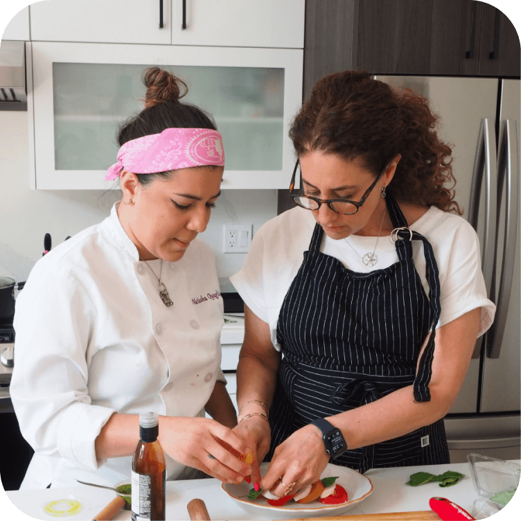 Two chefs working on a dish together.