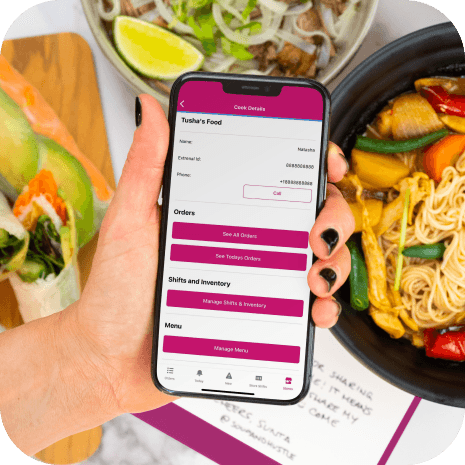 Hand holding smartphone in front of food.